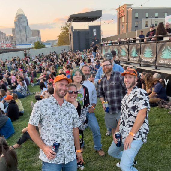 Folks pose for the camera outside a music venue in Northern Kentucky with the Cincinnati Skyline in the background