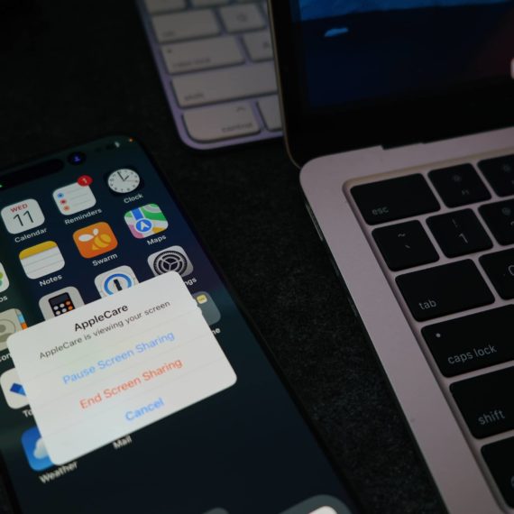 Phone next to laptop and keyboard with an active support call from Apple