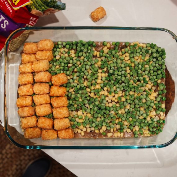 Tater Tot hot dish with frozen peas, frozen corn and a meat and mushroom base