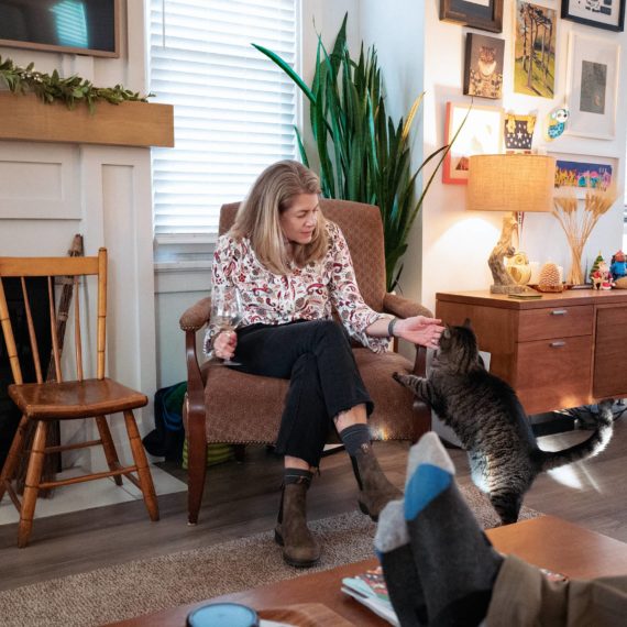 Cat approaches seated woman with caution