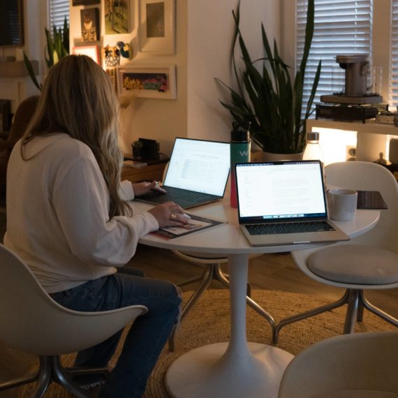 Woman works on laptop at dining table