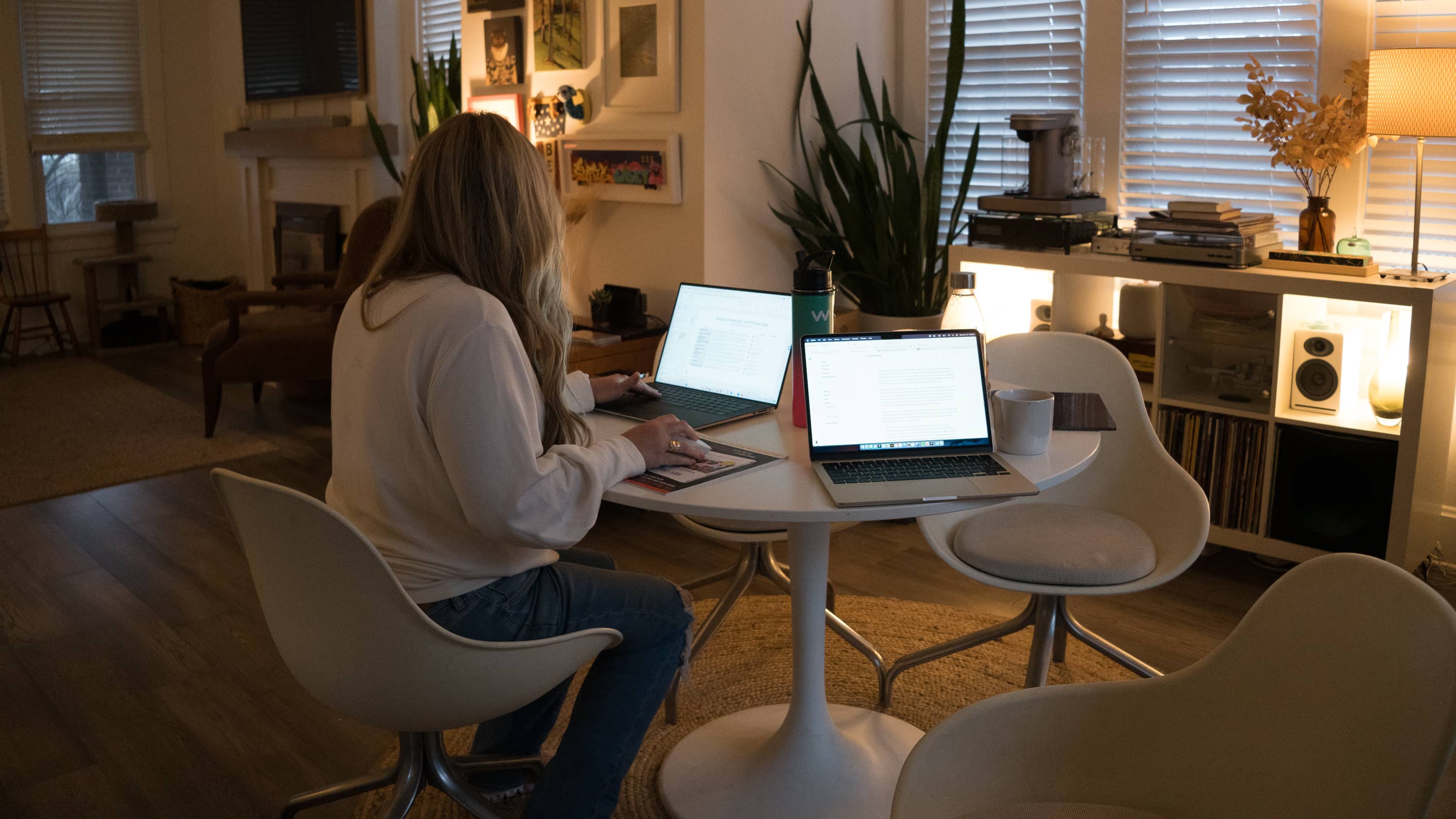 Woman works on laptop at dining table