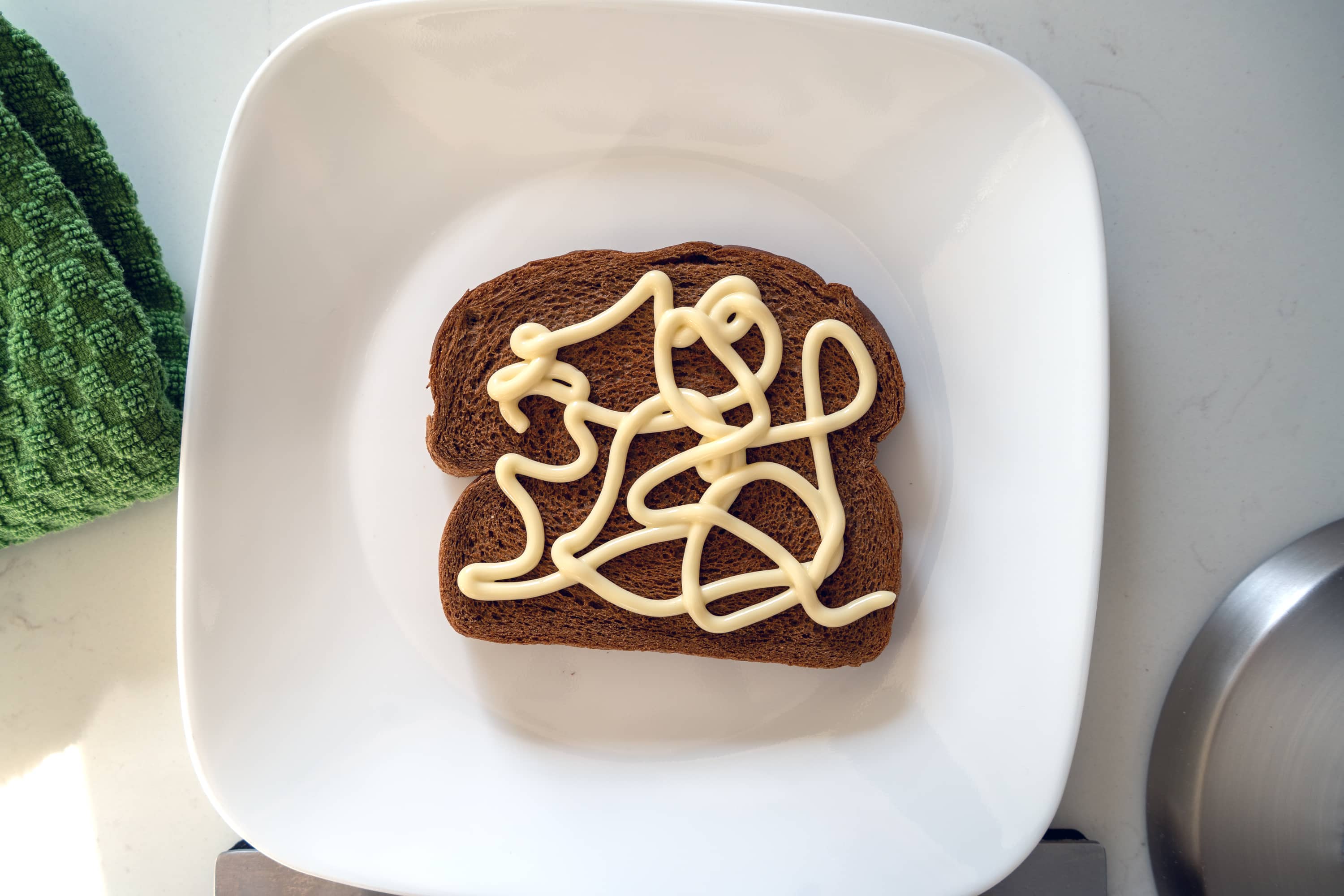 Rye bread with a squiggle of mayo on a plate