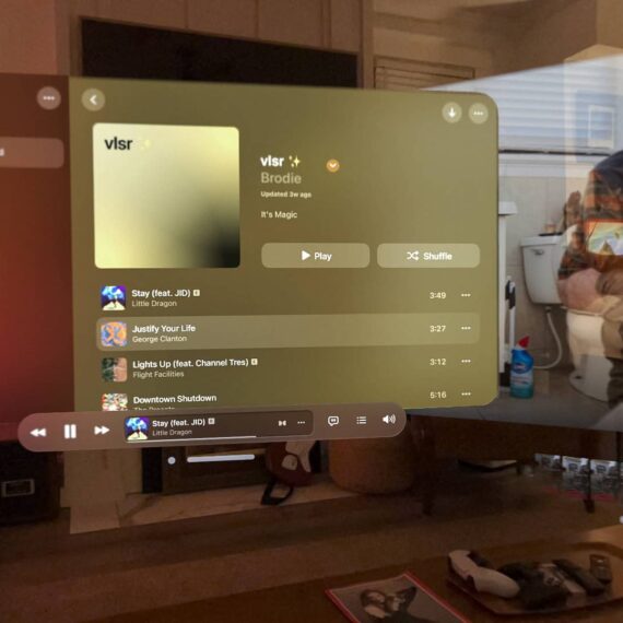 Screenshot from within the Apple Vision Pro. Apple Music is in focus, in the background is a man on the toilet