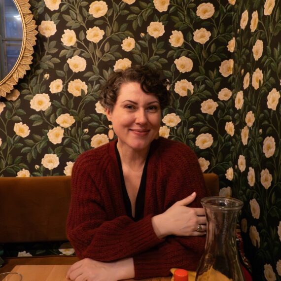 Woman in restaurant with flowered wallpaper