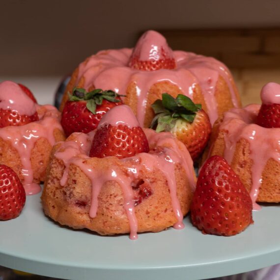 A serving plate full of strawberries and strawberry cakes